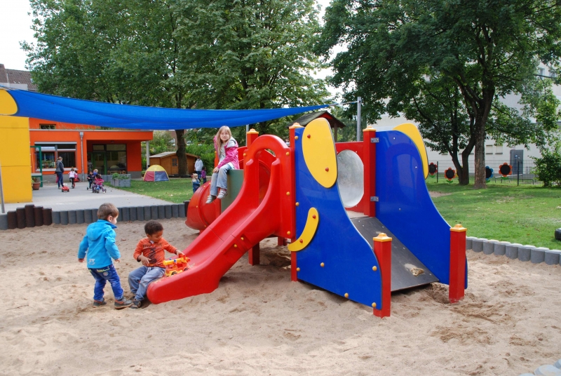 Sandkasten mit großer Rutschbahn mittendrin