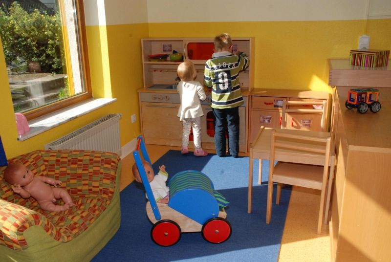 Zwei Kinder spielen mit der Holz-Einbauküche